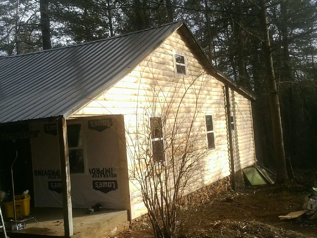 Log siding gable end under a dark metal roof edge in Tulsa
