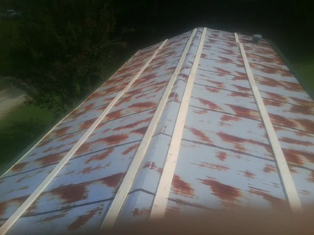 Rusted metal roof panels with new wood purlins before replacement — Storm Damage Roof Repair in Tulsa by Roofing Brothers