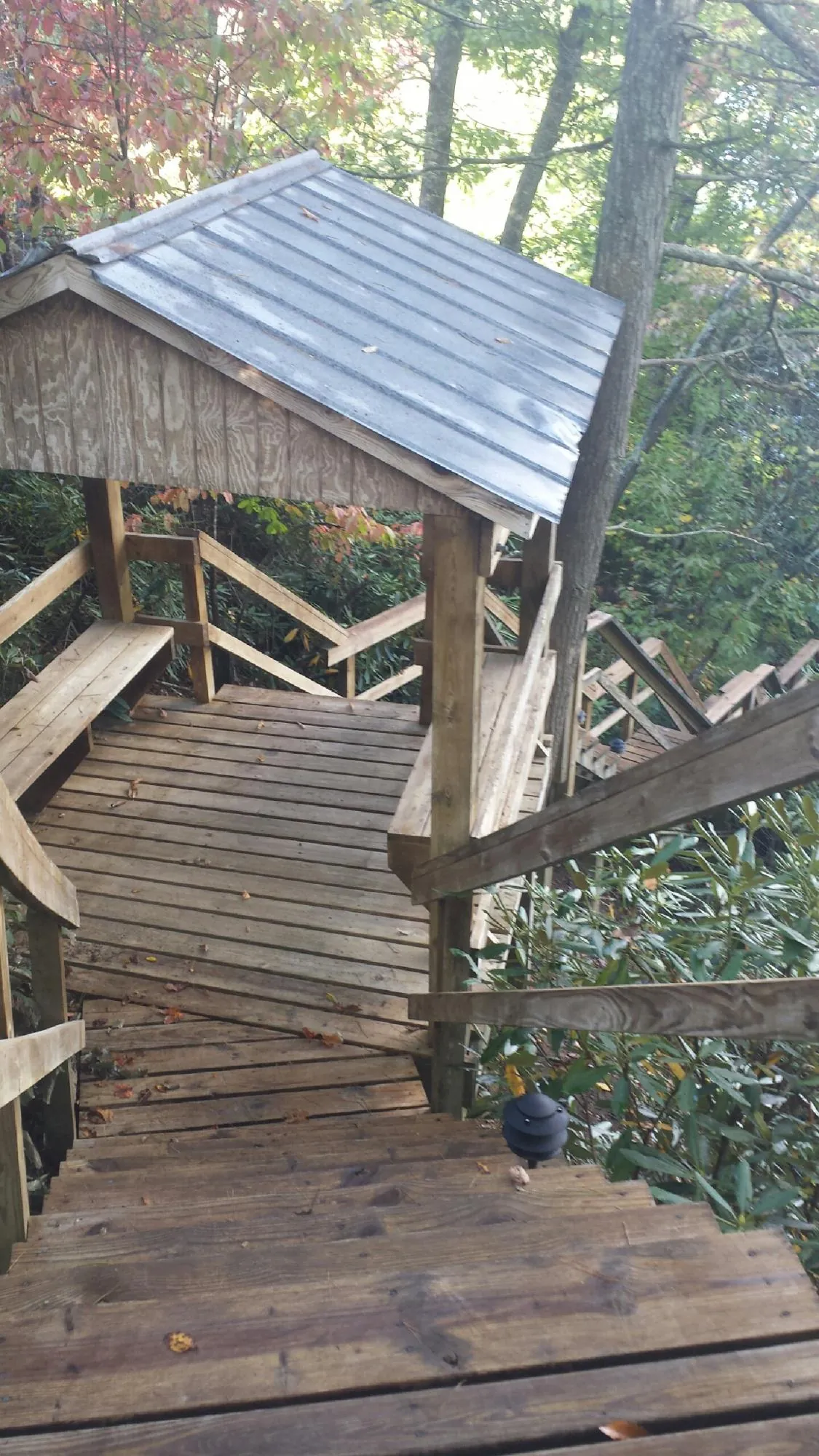 Metal roofed shelter over wooden steps on a wooded walkway — Skylight Repair & Installation work by our crew in Tulsa