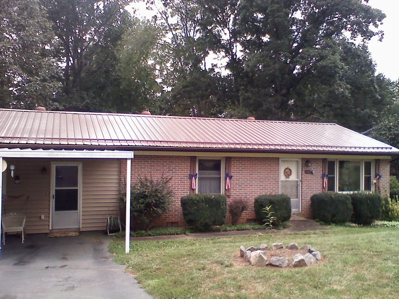 Bronze metal roof and carport on a brick ranch home — Roof Repair work by our crew in Tulsa